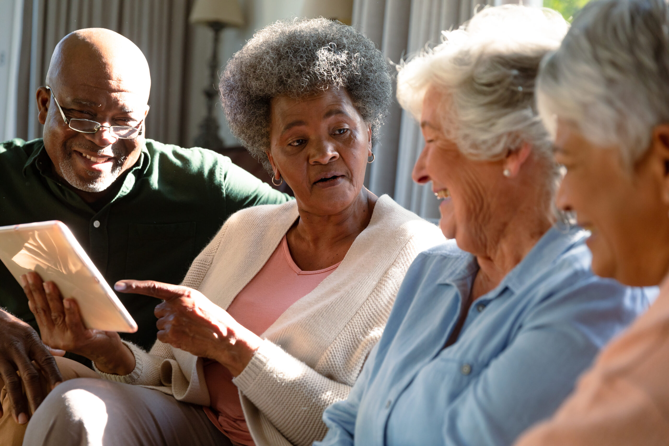 Diverse group of older adults looking at a tablet